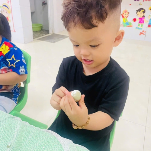 Bé lớp mầm học kỹ năng bóc trứng