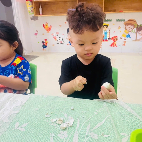Bé lớp mầm học kỹ năng bóc trứng