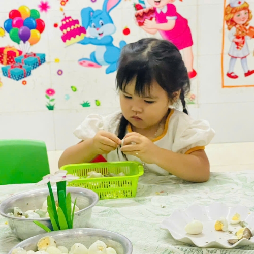 Bé lớp mầm học kỹ năng bóc trứng