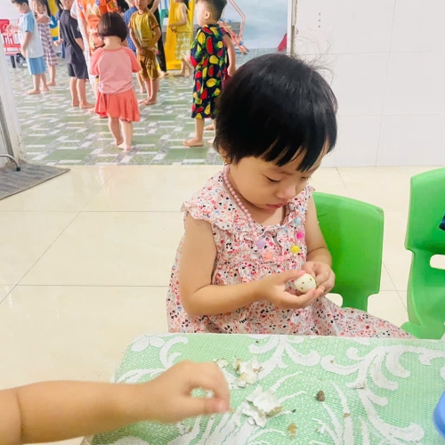 Bé lớp mầm học kỹ năng bóc trứng
