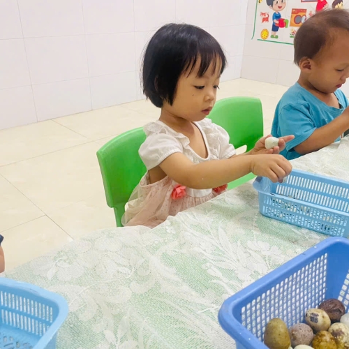 Bé lớp mầm học kỹ năng bóc trứng