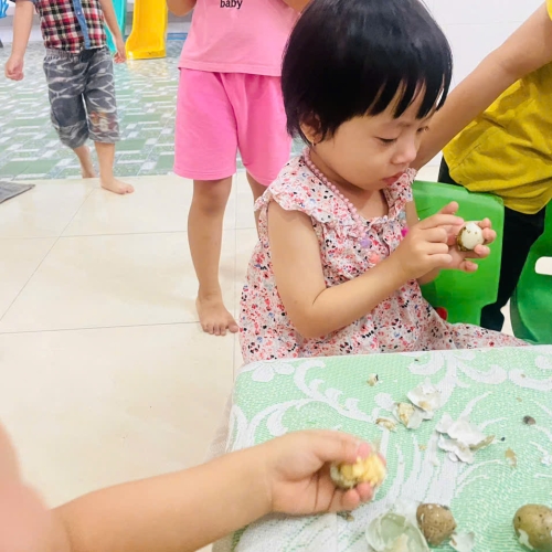 Bé lớp mầm học kỹ năng bóc trứng